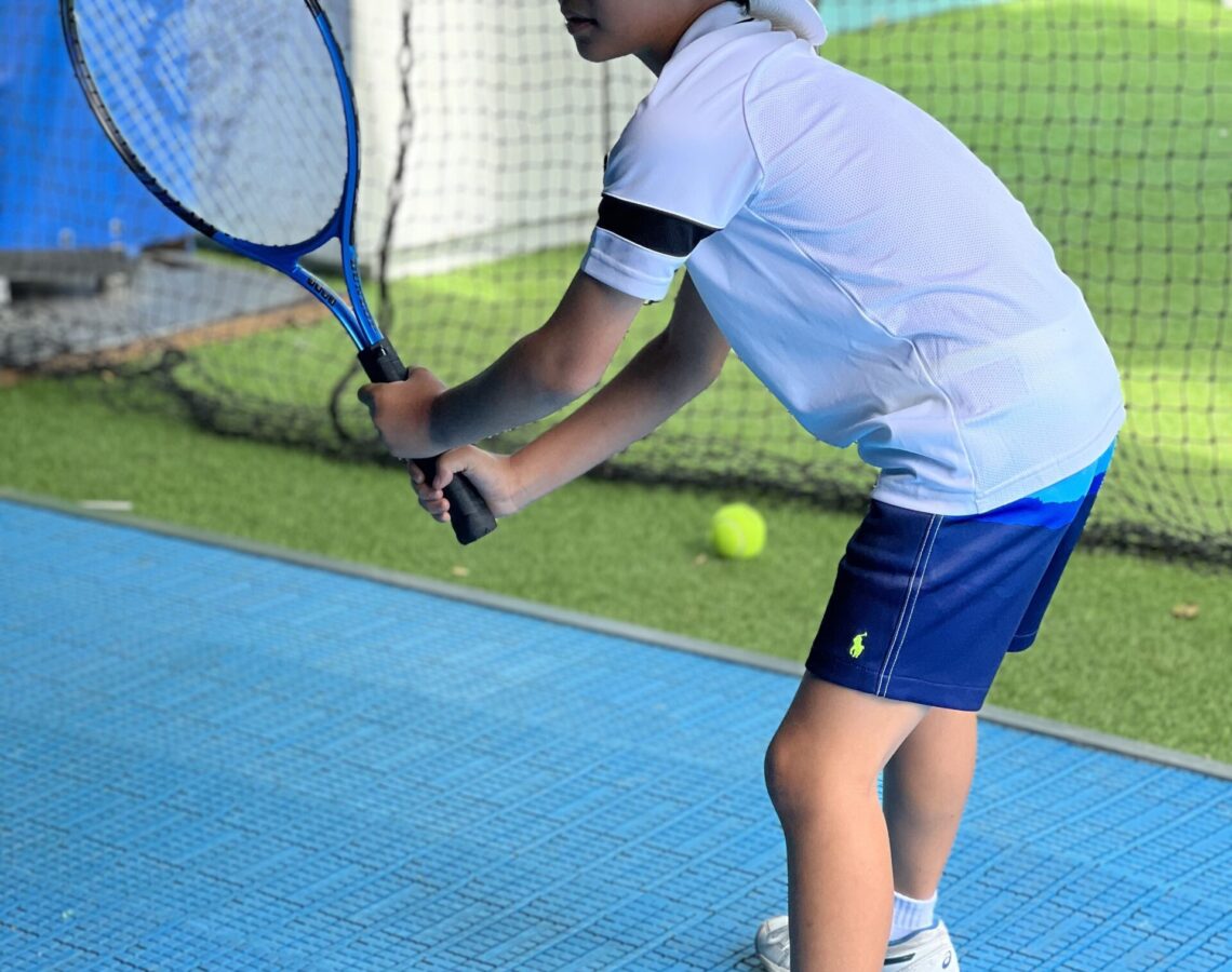 Kid enjoying Tennis on a tennis simulator