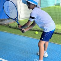 Kid enjoying Tennis on a tennis simulator